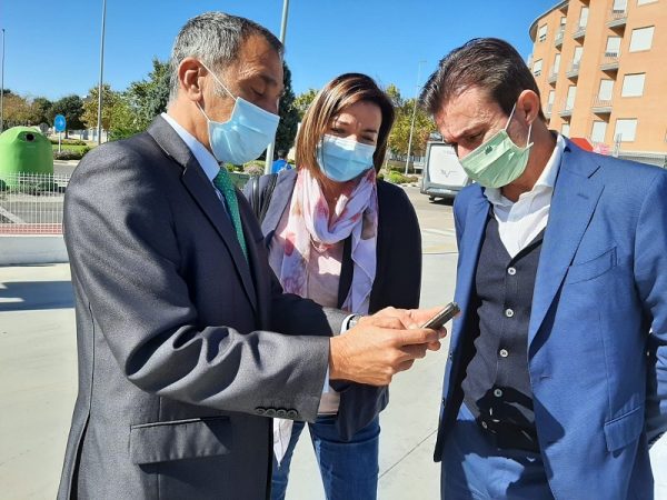 Planells (izq.) y Molina muestran a Amparo Navarro la aplicación móvil para la recarga