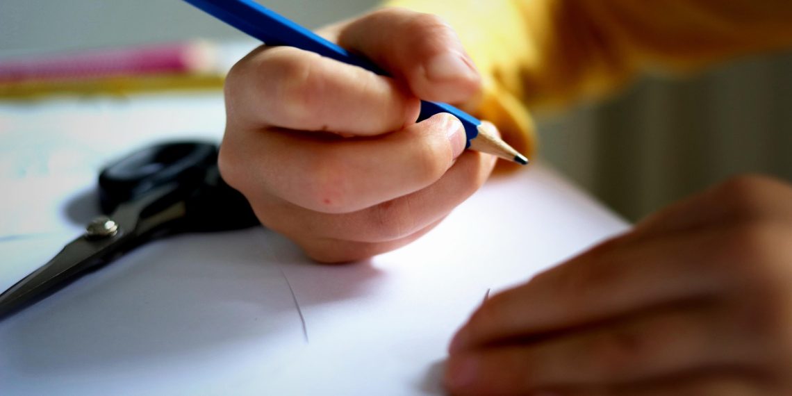 Niño escribiendo y haciendo los deberes para el colegio. La vuelta al cole