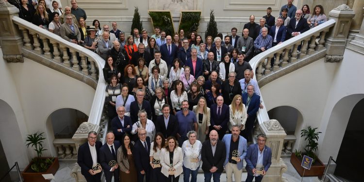 Foto de grupo de los premiados y autoridades durante la clausura del V Encuentro de Mercados Tradicionales en el Hemiciclo del Ayuntamiento de Valencia.