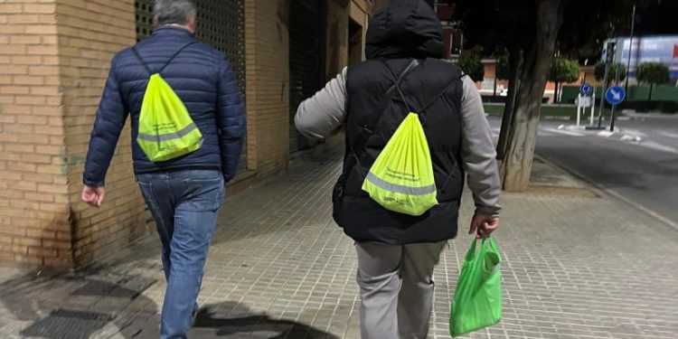 Voluntarios y equipos de Servicios Sociales organizan el reparto antes de iniciar el recuento nocturno en Torrent.