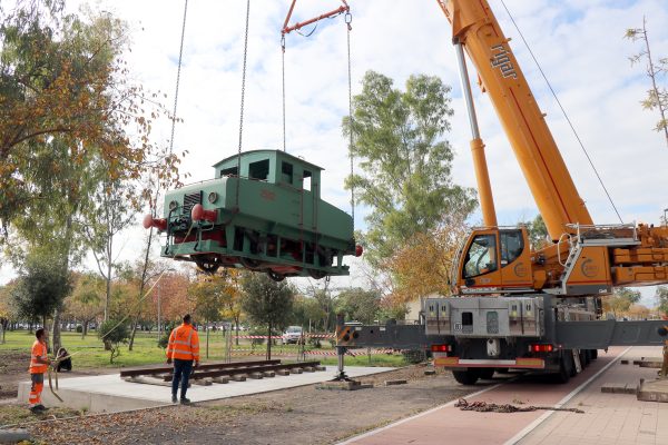 Operarios municipales ultiman la colocación de la histórica locomotora en su nuevo emplazamiento.